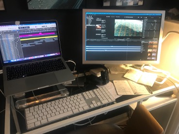 Two computer screens and keypads showing process of editing sound and video