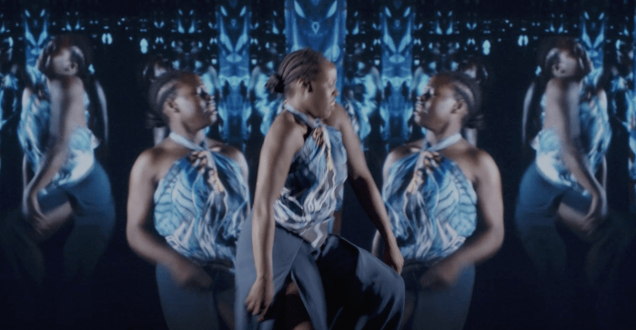 Women dressed in blue dancing against a blue background