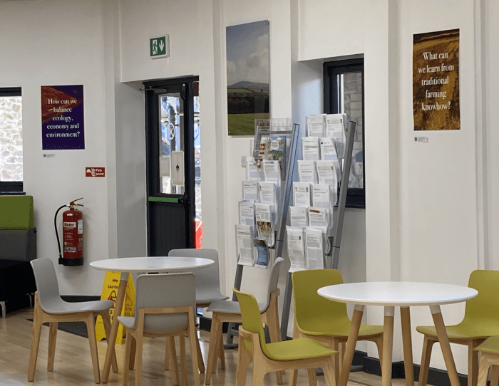 A canteen area with chairs, tables, and posters on the wall